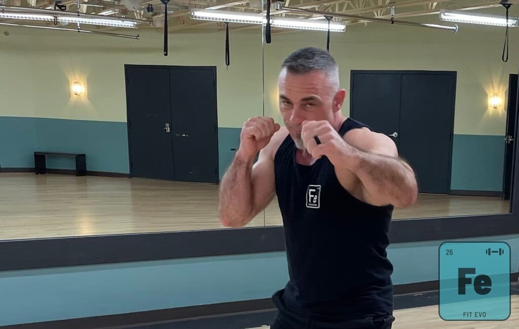 A close view of an instructor holding a boxing guard in the FIT EVO studio.