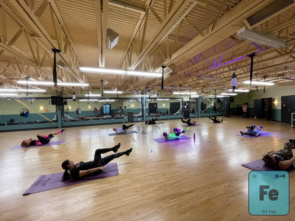A large mat class working on the floor of the FIT EVO studio.