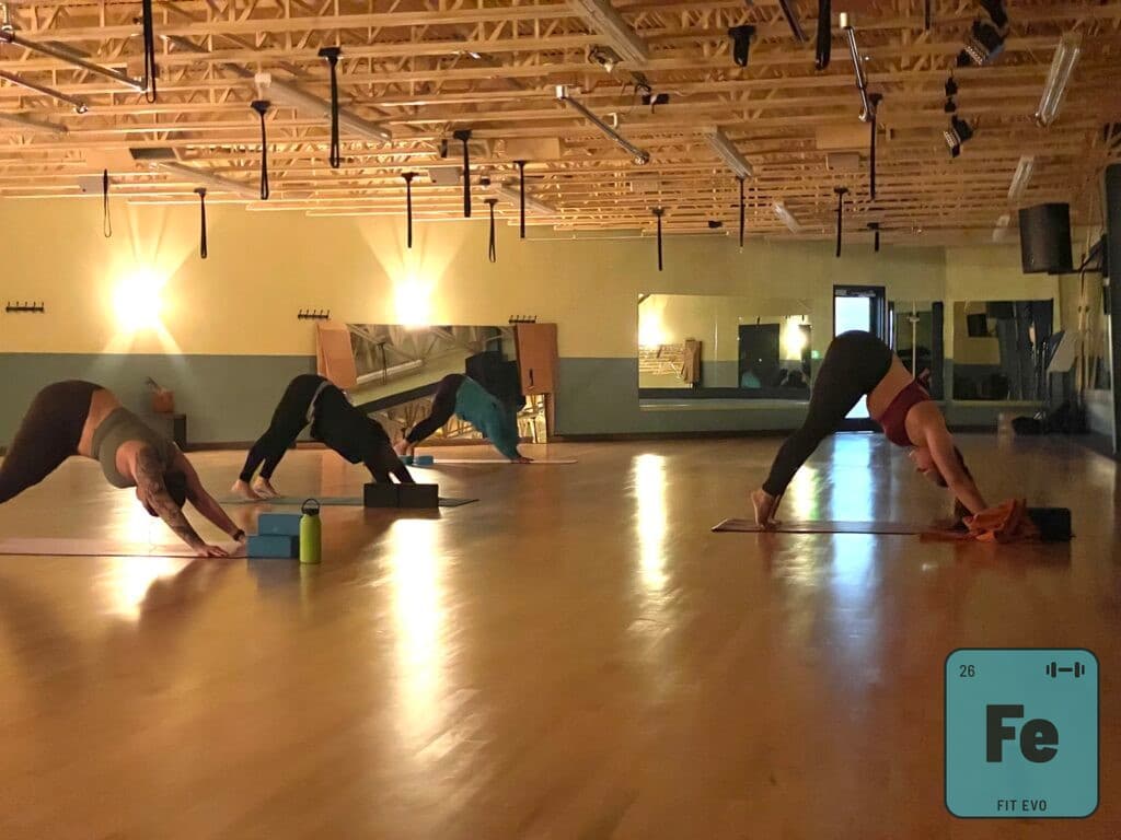 A yoga class holding downward-facing dog.