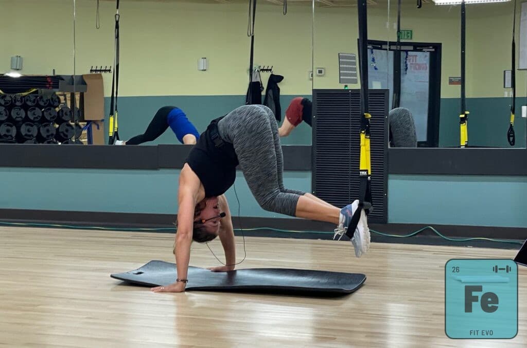 A member drawing into a pike with feet in TRX suspension straps.