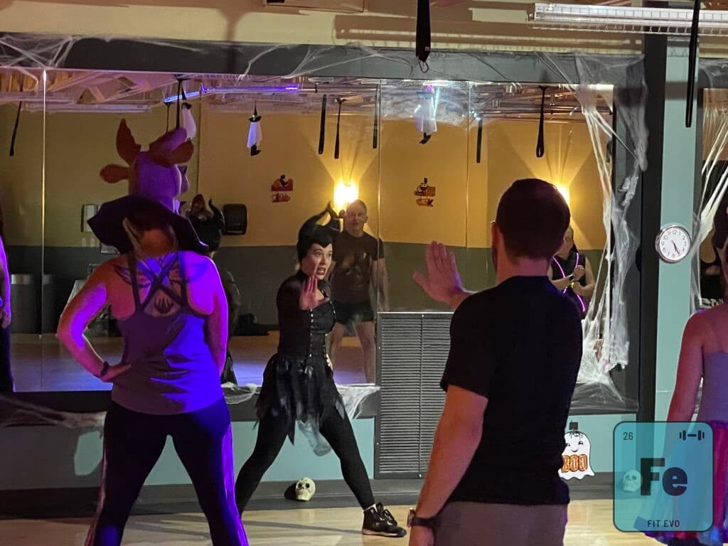 Members in costume dancing during a Halloween class in the FIT EVO studio.