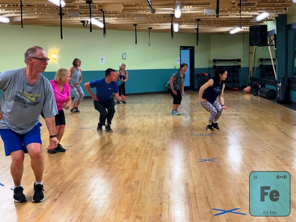 A mixed-age class following an instructor in the FIT EVO studio.