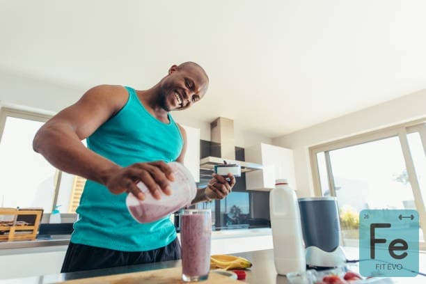 A member blending a drink behind the counter at the FIT EVO smoothie bar.