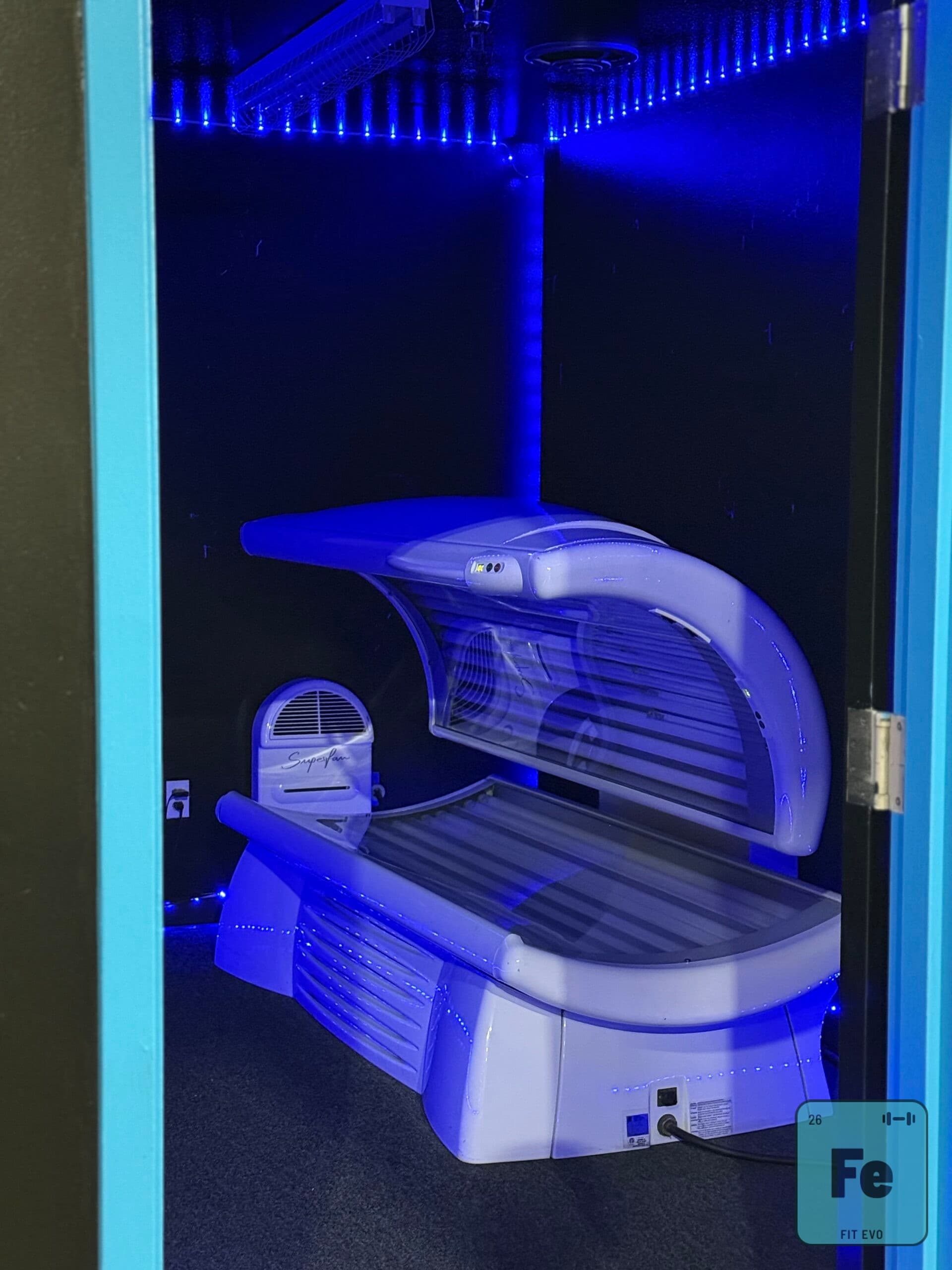 A lie-down tanning bed in a FIT EVO tanning room.