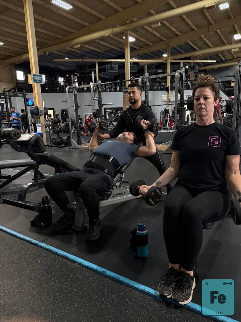 Members training with dumbbells on the FIT EVO weight floor.
